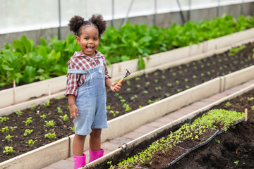 African black child playing planting the green tree gardening in agriculture farm. Children love nature concept.