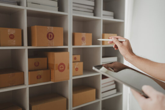 tablet are being used to do various activities to promote sales to stores, owner of an online store packs products into parcel boxes based on orders from online sales sites.