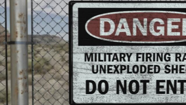 High quality 3D CGI render of a chainlink fence at a high security installation in a desert scene, with a Danger Military Firing Range sign