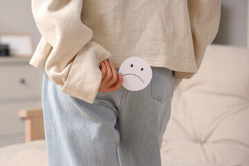 Mature woman with sad smile at home, back view. Hemorrhoids concept
