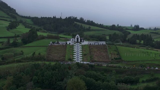 Wide view of Ermida de Nossa Senhora da Paz chapel On Hill Against Cloudy Sky - Azores, Portugal