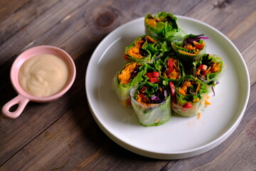 Spring rolls are a rolled appetizer or dim sum commonly found in Chinese and Asian cuisine. Raw fresh vegetable salad roll with mayonnaise.