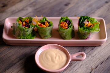 Spring rolls are a rolled appetizer or dim sum commonly found in Chinese and Asian cuisine. Raw fresh vegetable salad roll with mayonnaise.