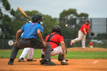 Men playing baseball game. Batter getting ready to hit a pitch during ballgame on a baseball diamond