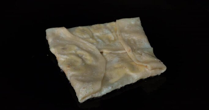 Slow Motion Roti stuffed with sliced bananas fried in pan