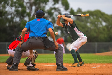 Men playing baseball game. Batter getting ready to hit a pitch during ballgame on a baseball diamond