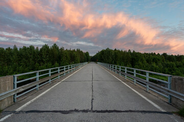 A road and a bridge on a moody summer night in Northern Finland