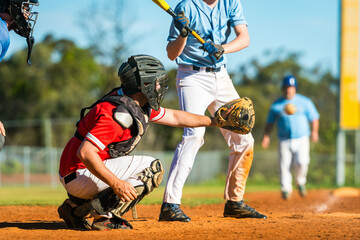 Men playing baseball game. Catcher is trying to catch a baseball during ballgame on a baseball diamond - obrazy, fototapety, plakaty