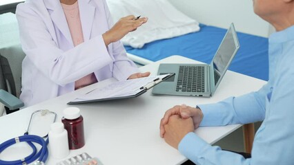 An elderly Asian male patient answers questions from an elderly female doctor. health advice and discuss comprehensive health care in a healthcare environment. Health insurance concept.