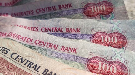 Three one hundred dirhams (AED) united arab emirates (UAE) national currency banknotes closeup...