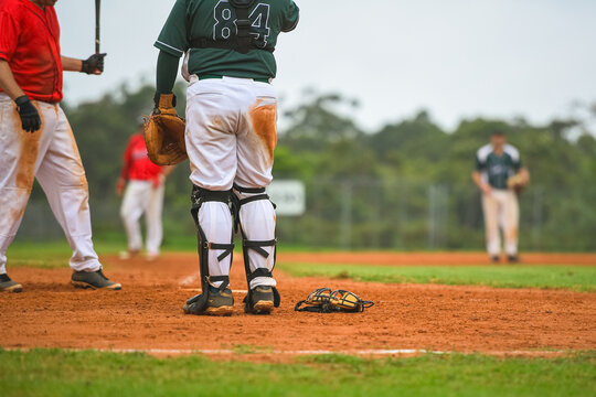 Baseball game, catcher is standing up and cather's mask is lying on the ground during the ball game.