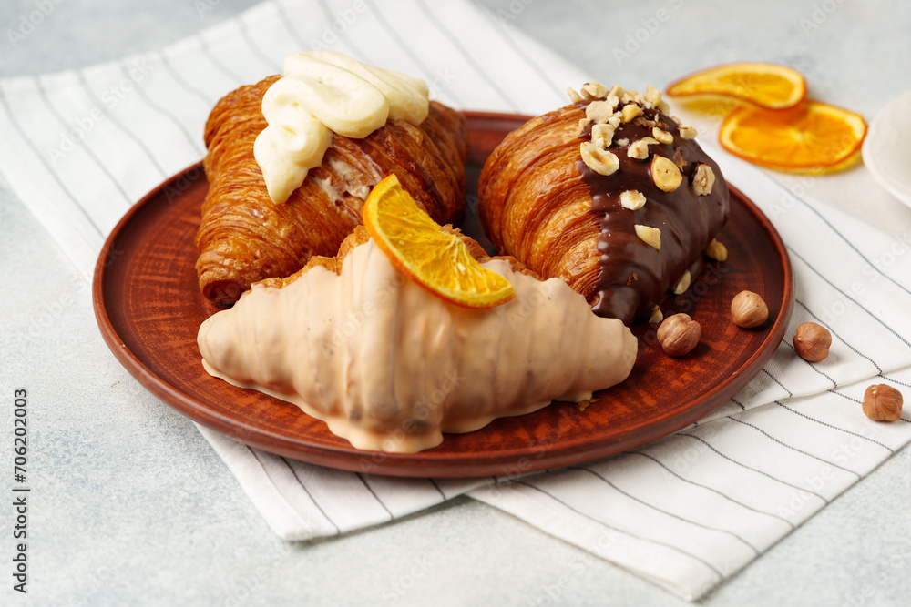 Wall mural Glazed croissants on clay plate on table