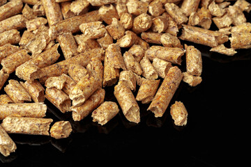 Heap of wood pellets biofuel on black background