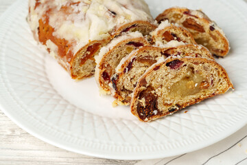 Christmas stollen on plate on white wooden table