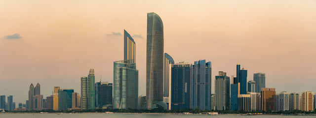 The corniche and skyline of Abu Dhabi after sunset, with futuristic and modern skyscrapers. Blue...