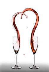 Shape of heart splashes out from two wine glasses. White isolated background - 706225888