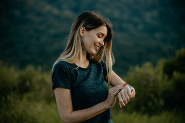 Jogging woman syncing her outdoor run with a smartwatch for real-time data