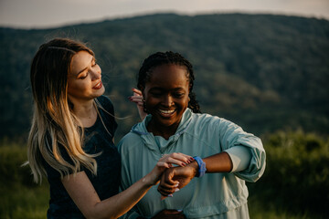 Two friends, one lean and one curvy, enjoying a jog together and syncing their smartwatches