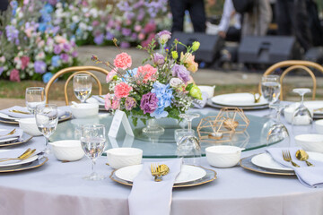 Beautiful flowers decorated on the table.Tables set for an event party or 
wedding reception. luxury elegant table setting dinner in a restaurant