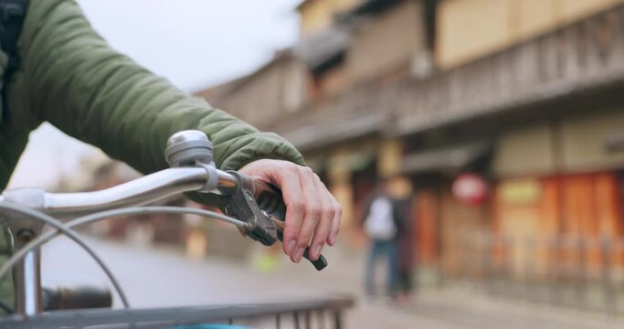 Hands, bicycle and brake handle in street, travel and transport outdoor of active rider on urban road for health. Closeup, press handlebar and person cycling to control or check bike in Kyoto Japan