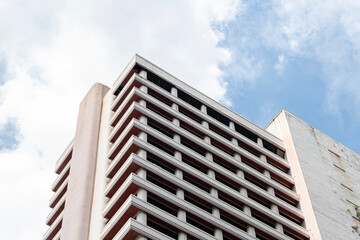 Fototapeta premium Bottom up view old apartment building with blue sky background