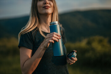 Active woman sips water, staying hydrated after jogging outdoor