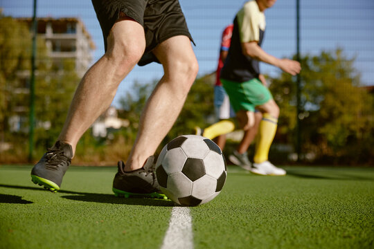 Soccer player kicking ball cropped shot, amateur football match