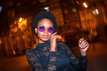 Fashionable african woman dancing in the street at night