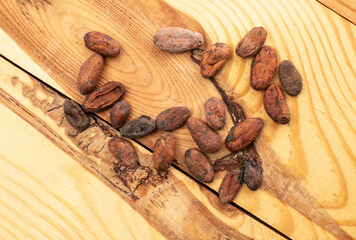  Several cocoa beans on a wooden table, macro, top view.