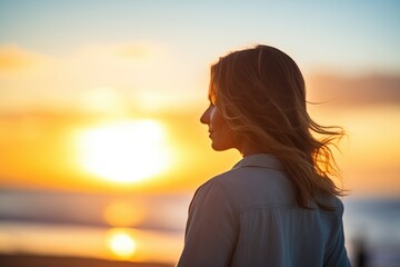 backlit silhouette of a person against a sunset on the beach