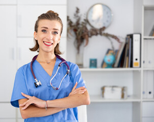 Woman doctor wear blue medical uniform and stethoscope look at camera posing in private clinic