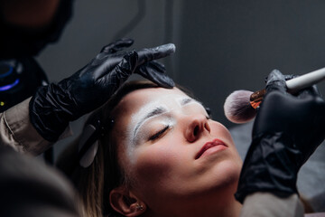 The makeup artist performs permanent makeup. Professional makeup and facial care. Eyebrow and lip...