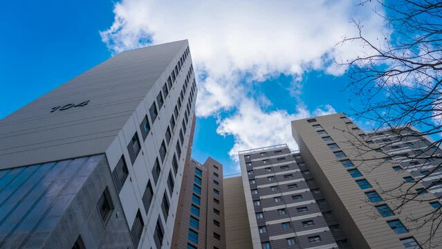 Time-lapse capture of clouds flowing across the sky of an apartment complex