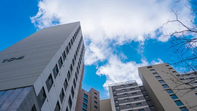 Time-lapse capture of clouds flowing across the sky of an apartment complex