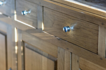 Drawer knob on a light oak cabinet, perspective view