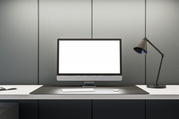 Stylish workspace with computer and desk lamp on gray wall background. Office simplicity concept....