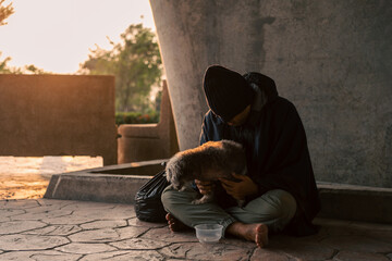 Homeless man and dog on the street waiting for help food and money from people volunteer foundation donate. Poor tired stressed depressed hungry homeless man