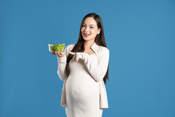 Portrait of pregnant asian woman, isolated on blue background