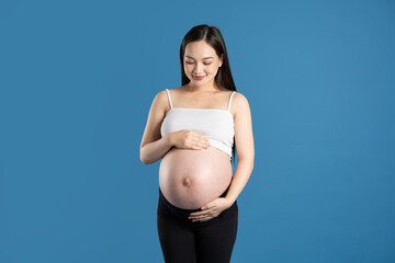 Portrait of pregnant asian woman, isolated on blue background