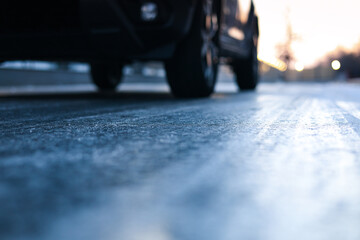 Icy road. Close up photo with the asphalt covered with ice after a freezing rain in the winter morning. Danger for driving. - obrazy, fototapety, plakaty