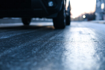 Icy road. Close up photo with the asphalt covered with ice after a freezing rain in the winter morning. Danger for driving. - Powered by Adobe