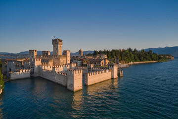 Obraz premium Scaliger Castle in Sirmione on Lake Garda Italy, aerial view at sunrise.