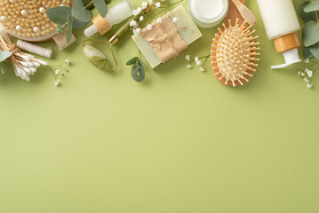 Organic self-care essentials. Top view of jade roller, skincare products, wooden hairbrush,...