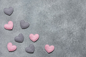 Corner of pink and gray hearts on a concrete background. Valentine's day. Top view, flat lay, copy space.