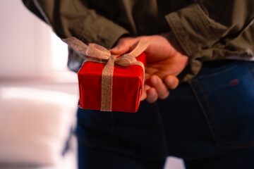  portrait young man hides small box to give to his partner.Valentine's Day.