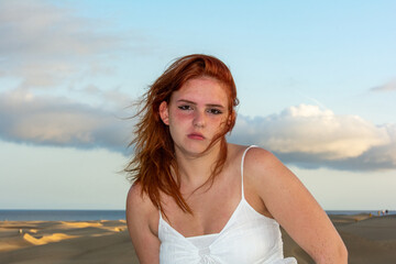 Fototapeta na wymiar Young woman on the beach with windblown hair