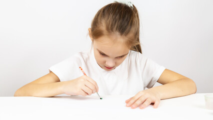 Naklejka premium Caucasian child girl painting at table indoors