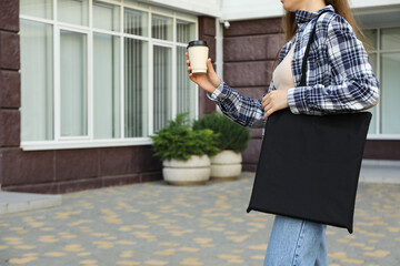 A woman with coffee and a bag on her shoulder