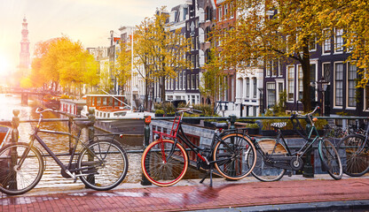 Amsterdam, Netherlands. Bikes over canals of amsterdam city, autumn yellow leaf fall. Picturesque...