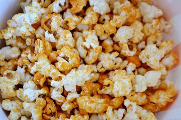 A striped bucket with flying popcorn isolated on a white background.